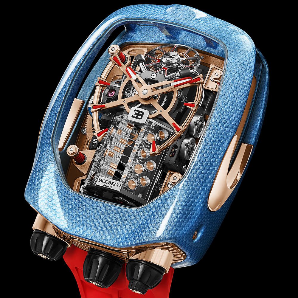 Top view of a high-end watch with a textured blue case, red strap, and skeleton dial showing the movement.