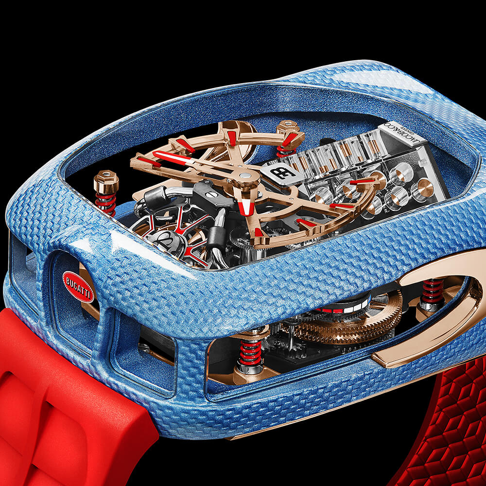 Side view of a high-end watch with a textured blue case, red strap, and visible skeleton movement.